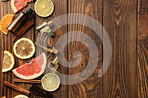 Composition with essential oils and citrus fruits on wooden background