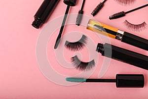 Composition with false eyelashes, mascara and eyelash brushes, eyelash curlers on background.