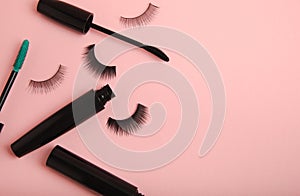 Composition with false eyelashes, mascara and eyelash brushes, eyelash curlers on background.