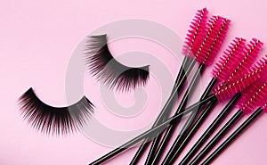 Composition with false eyelashes, mascara and eyelash brushes, eyelash curlers on background.