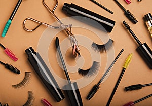 Composition with false eyelashes, mascara and eyelash brushes, eyelash curlers on background.