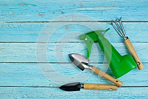 Composition with flowers and gardening tools on the wooden background with space for text. Top view.