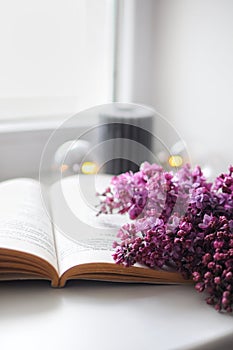Composition of flowers. Vintage opened book with lilacs. Morning routine