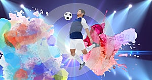 Composition of football player with ball over colourful splodges and sports stadium background