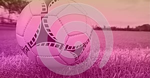 Composition of football on white line on grass pitch with copy space and pink tint