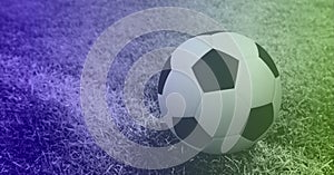 Composition of football on white line on grass pitch with copy space and purple tint