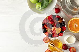 Composition fresh fruit salad on white wooden table, top view
