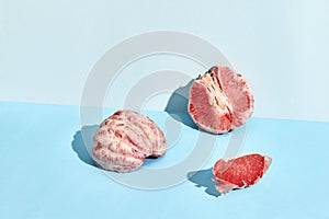 Composition of fresh fruits, juicy grapefruit cutted into slices on two-color background