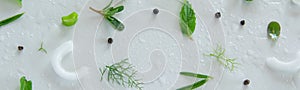 Composition of fresh green vegetables and herbs on white background. Vegetable salad ingredients. Creative food pattern