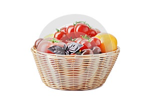Composition of fresh ripe tomatoes of different varieties in a basket isolated on white