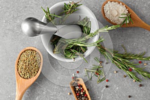 Composition with fresh rosemary and dried spices on grey background