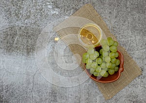Composition of a glass of white wine  a bunch of grapes on a plate photo