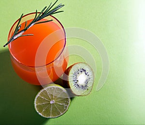 Composition of glasses with orange juice, lime, kiwi and verdure