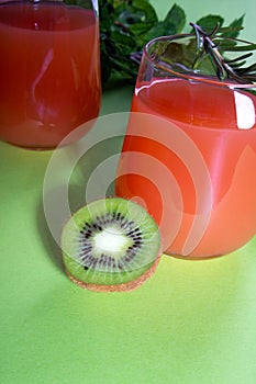 Composition of glasses with orange juice, lime, kiwi and verdure