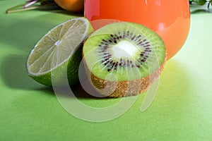 Composition of glasses with orange juice, lime, kiwi and verdure