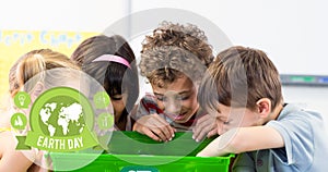 Composition of green globe logo and earth day text over children looking in recycling box