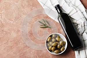 Composition of green olives and bottles of olive oil on the background.