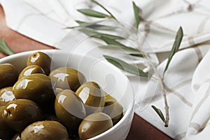 Composition of green olives and bottles of olive oil on the background.