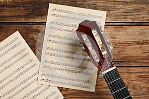 Composition with guitar and music notations on table, flat lay