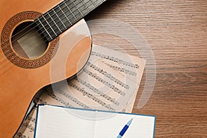 Composition with guitar and music notations on table, flat lay