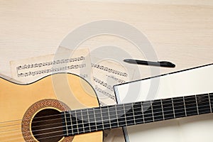 Composition with guitar and music notations on wooden table, flat lay. Space for text