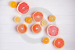 Composition with halves of different citrus fruits on white wooden background