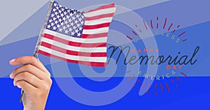 Composition of hand holding american flag over happy memorial day text, on blue stripes