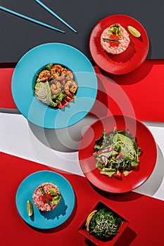 Composition with healthy salads , tartar, seafood salmon and tuna, Edible Green Algae Asian food on colorful background ,