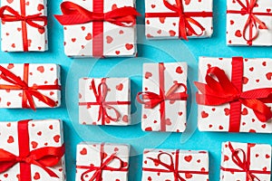 Composition of holiday white gift boxes with red hearts on colorful background. Valentine\'s day concept