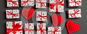 Composition of holiday white gift boxes and red textile hearts on colorful background. Valentine\'s day concept