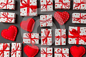 Composition of holiday white gift boxes and red textile hearts on colorful background. Valentine\'s day concept