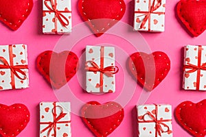 Composition of holiday white gift boxes and red textile hearts on colorful background. Valentine\'s day concept