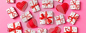 Composition of holiday white gift boxes and red textile hearts on colorful background. Valentine\'s day concept