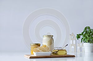 Composition of honey glass with honeycomb, teaspoo, on white table in rustic scenery.