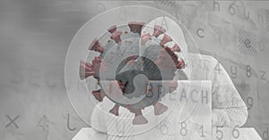 Composition of hooded hacker using laptop with covid cell and security breach warning on screen