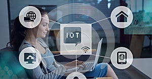 Composition of iot icon with network of connections over woman using laptop