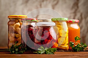 Composition with jars of pickled vegetables.