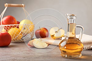 Composition with jug of apple vinegar on table