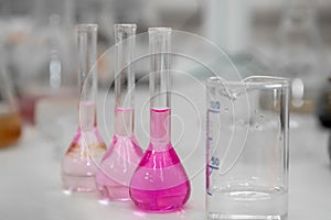 Composition of laboratory material with colored liquids in realistic glass pots