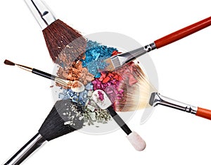 Composition with makeup brushes and broken eye shadow