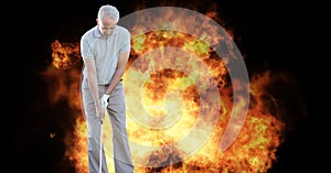 Composition of male golf player over flames on black background