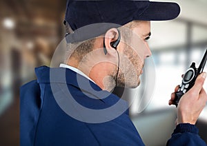 Composition of male security guard using walkie talkie and phone headset over blurred background