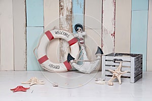 Composition on a marine theme with an anchor and life buoy, seashells and starfish on a wooden background