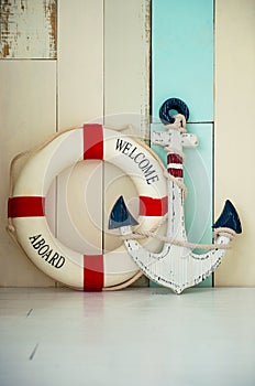 Composition on a marine theme with an anchor and life buoy, seashells and starfish on a wooden background