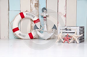 Composition on a marine theme with an anchor and life buoy, seashells and starfish on a wooden background