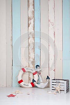 Composition on a marine theme with an anchor and life buoy, seashells and starfish on a wooden background