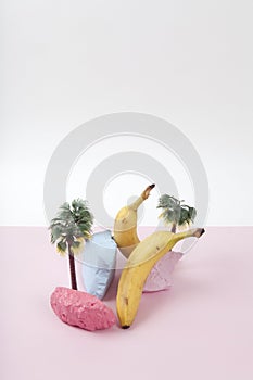 composition and metaphor for an island with palm trees, composed of ripe bananas and brightly painted pebbles
