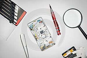 Composition with mobile phones and tools on grey background.