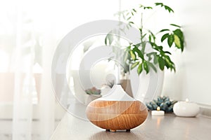 Composition with modern essential oil diffuser on wooden shelf indoors photo