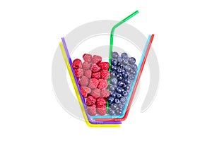 Composition of multi-colored cocktail tubes and berries isolated on white. Raspberries and blueberries in a glass